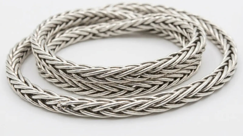Close-up of a sterling silver foxtail chain necklace showing its densely woven, braided link texture