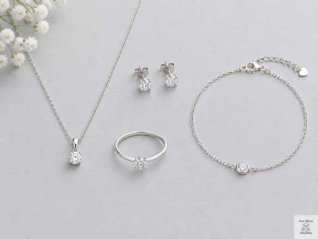 Flat lay of affordable sterling silver jewellery under £20 including a chain, pendant, stud earrings, ring and bracelet