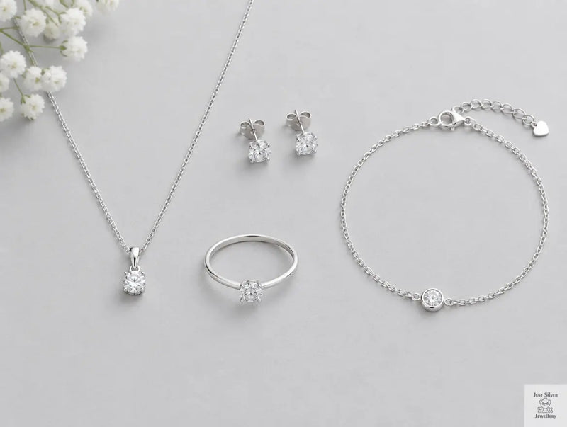 Flat lay of affordable sterling silver jewellery under £20 including a chain, pendant, stud earrings, ring and bracelet