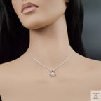 Mannequin wearing a silver necklace with a zirconia pendant on a dark background