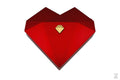 Three heart-shaped ring gift boxes in white, green, and red, with gold accents, displayed in an open presentation box.