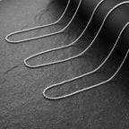 Silver chain on a dark textured surface