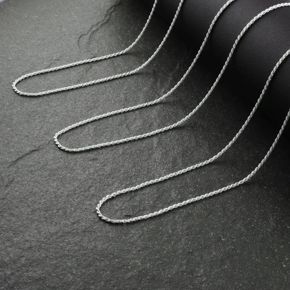 Silver chain on a dark textured surface