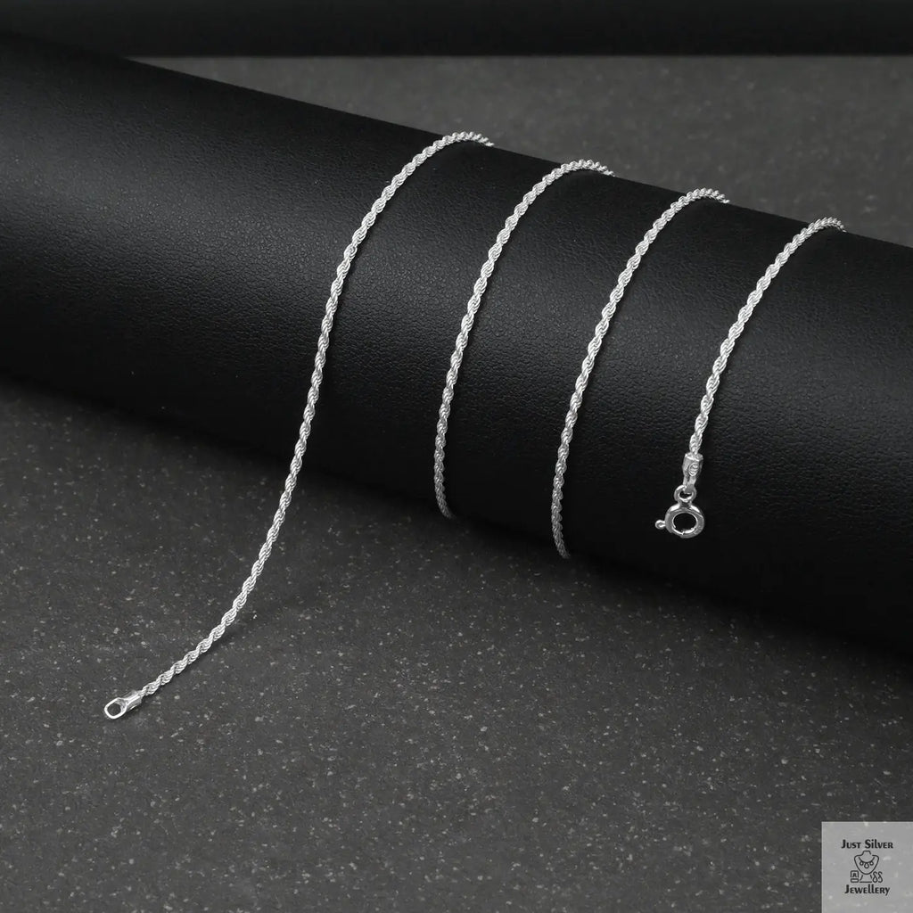 Silver rope chain necklace on a black background