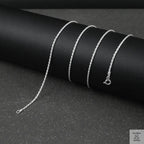 Silver rope chain necklace on a black background