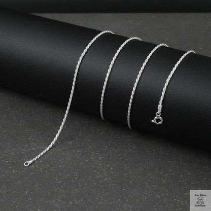 Silver rope chain necklace on a black background