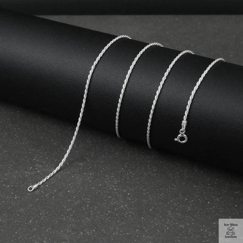 Silver rope chain necklace on a black background