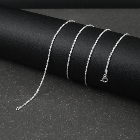 Silver rope chain necklace on a black background