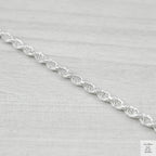 Silver rope chain on a light grey background