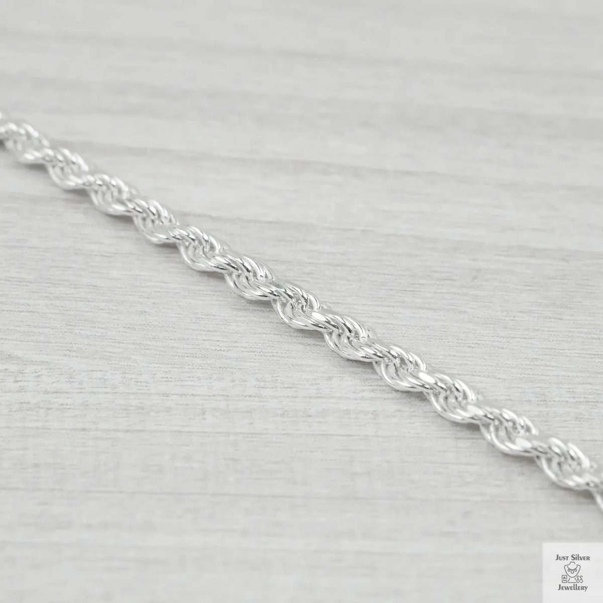 Silver rope chain on a light grey background
