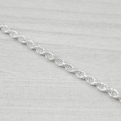 Silver rope chain on a light grey background