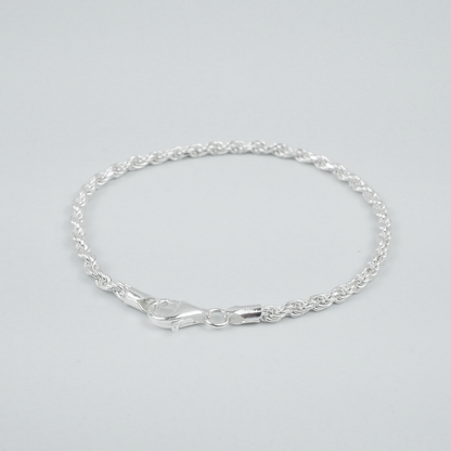 Silver rope bracelet on a light grey background