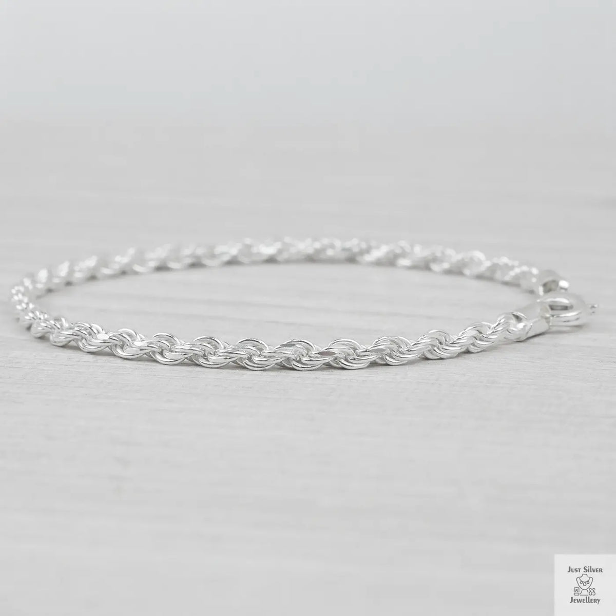 Silver rope bracelet on a light grey background