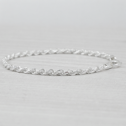 Silver rope bracelet on a light grey background