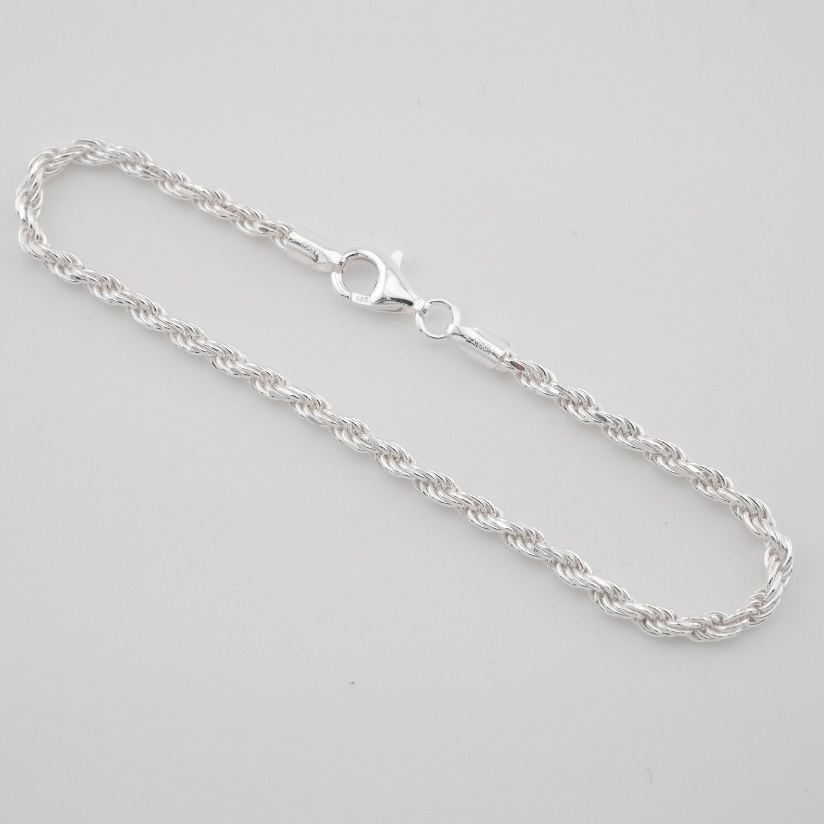 Silver chain necklace on a light gray background