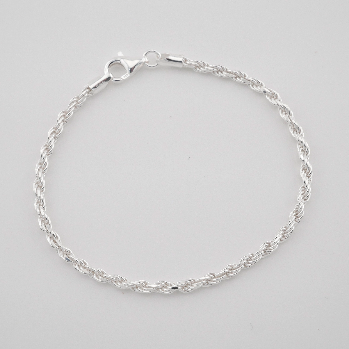 Silver bracelet on a light gray background