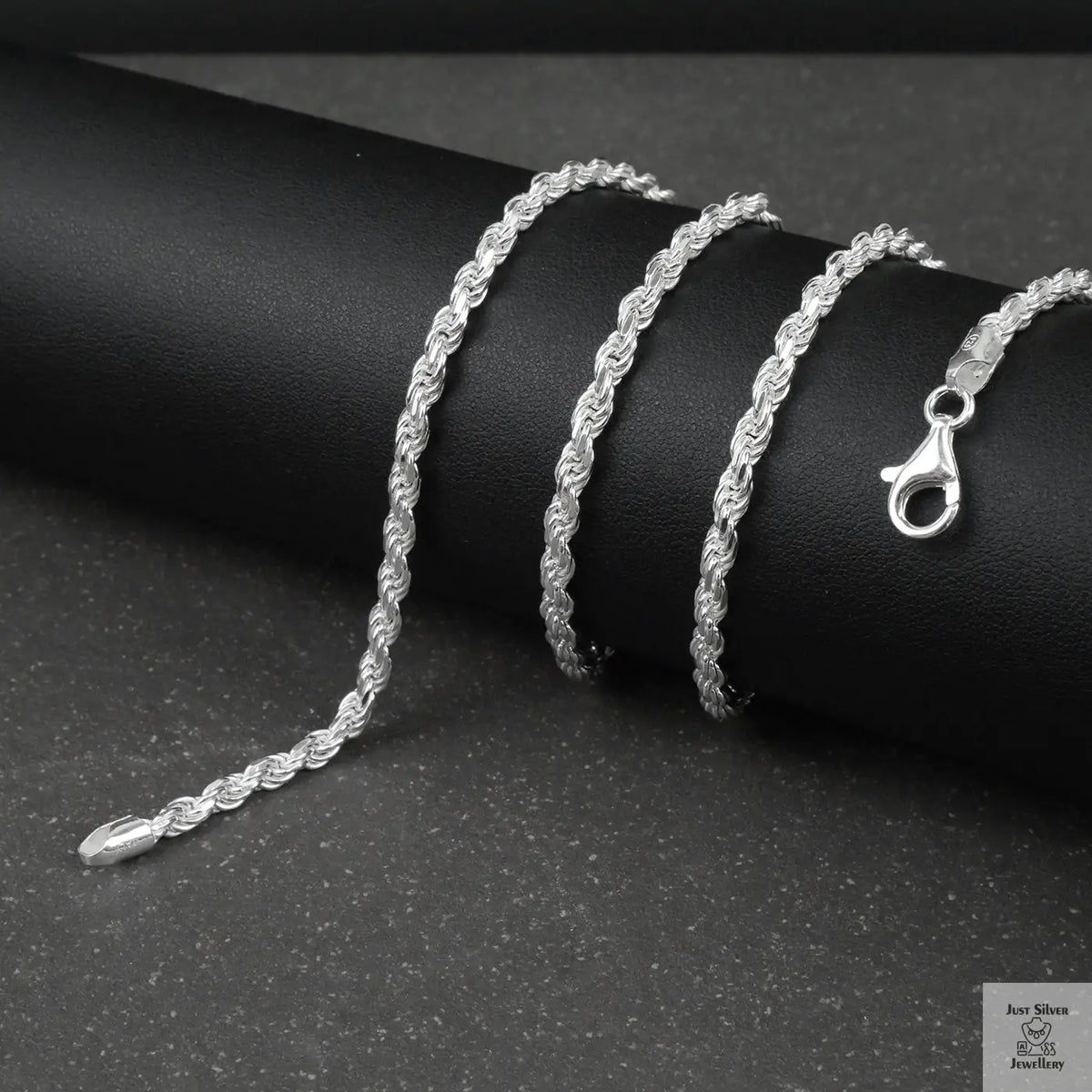 Silver rope chain on a black surface