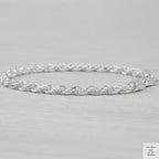 Silver rope bracelet on a light grey background