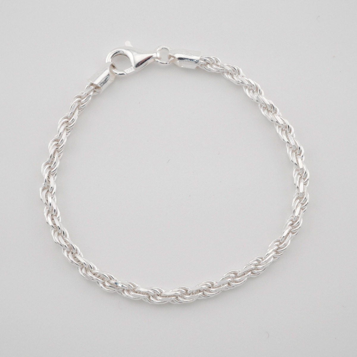 Silver bracelet on a light gray background
