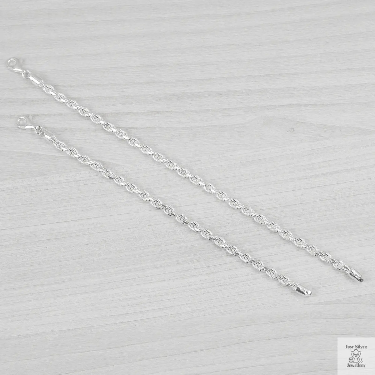 Silver bracelets on a light grey background