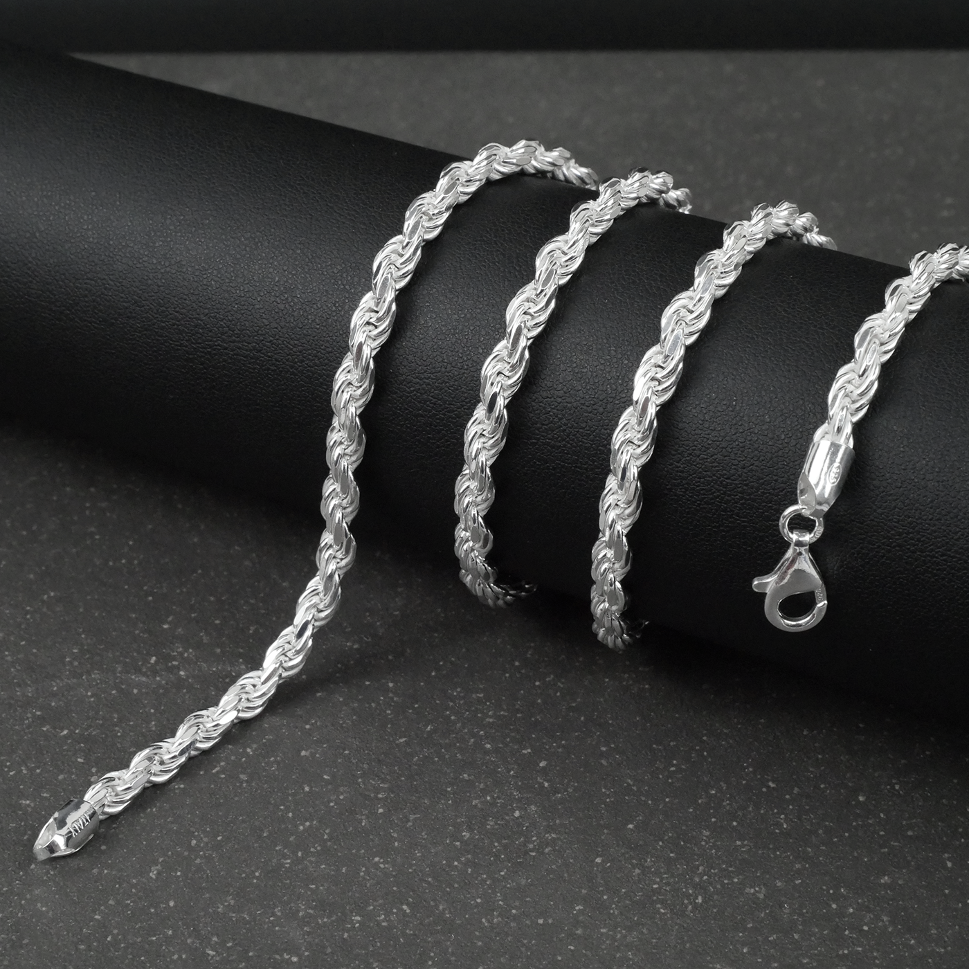 Silver rope chain on a black surface