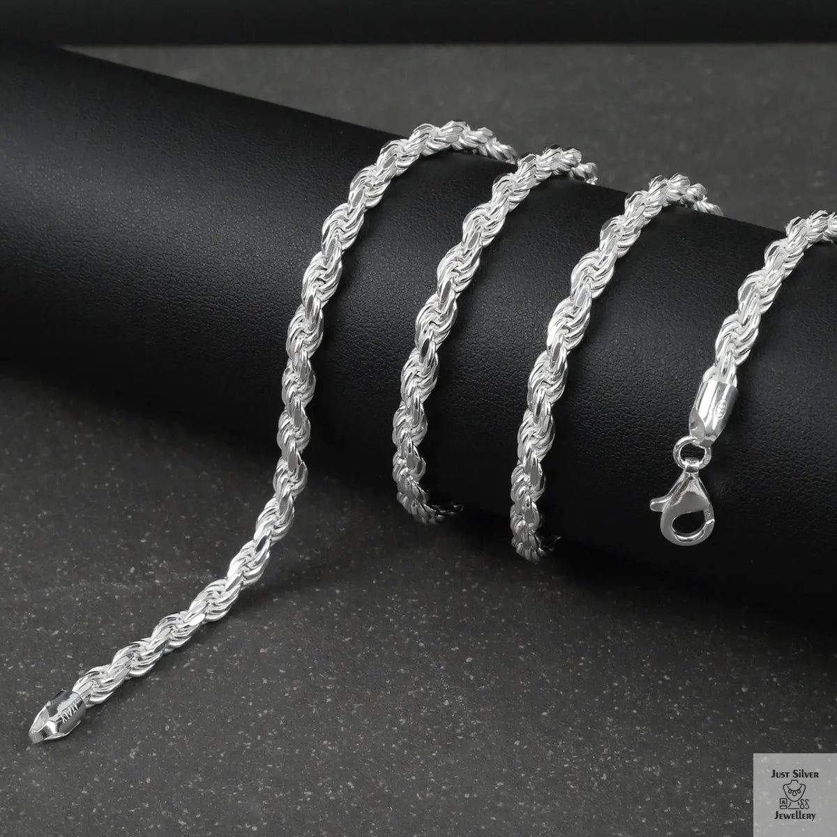 Silver rope chain on a black surface