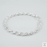 Silver rope bracelet on a light grey background