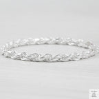 Silver rope bracelet on a light grey background