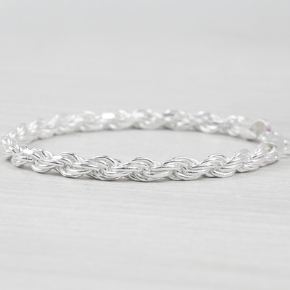 Silver rope bracelet on a light grey background