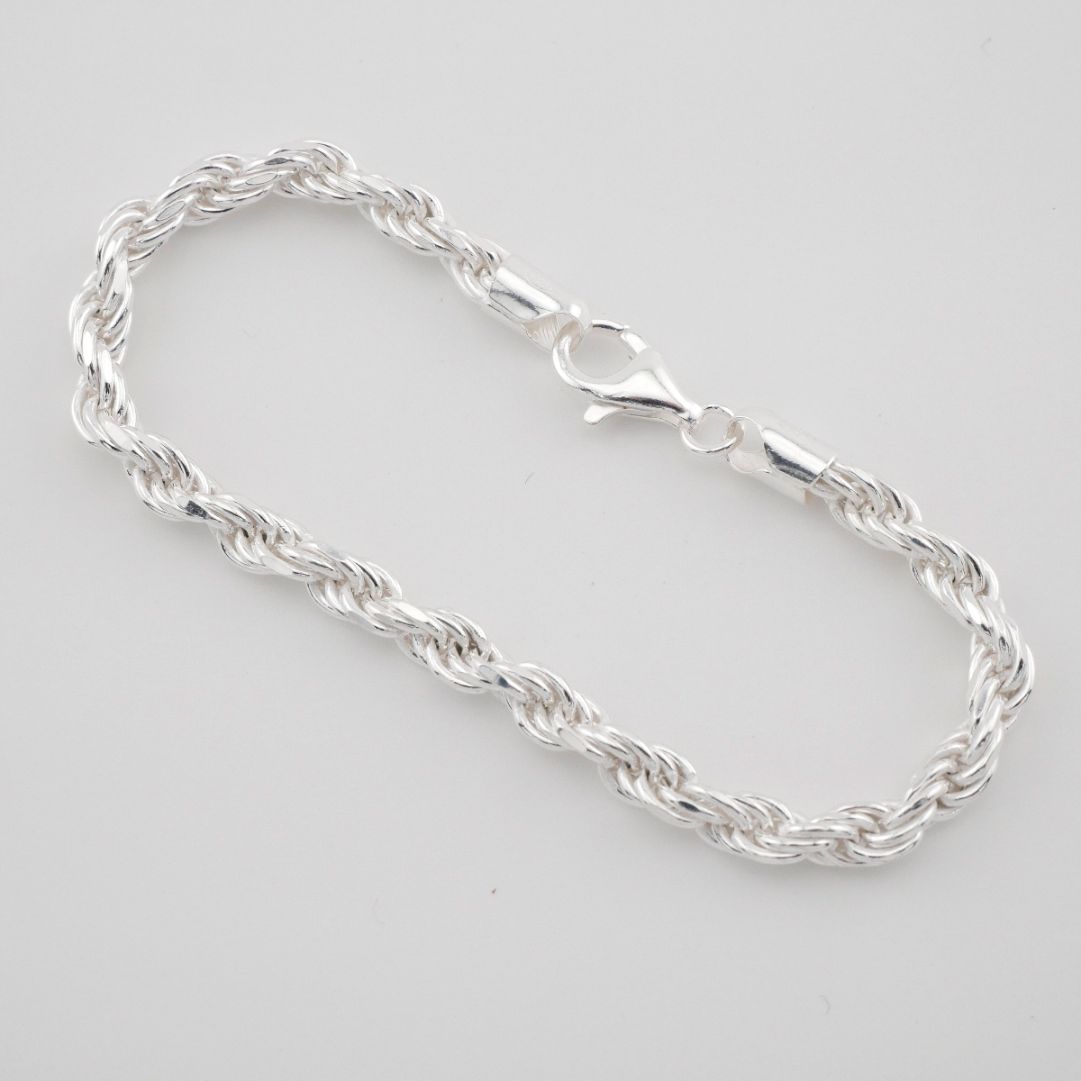 Silver chain bracelet on a light gray background
