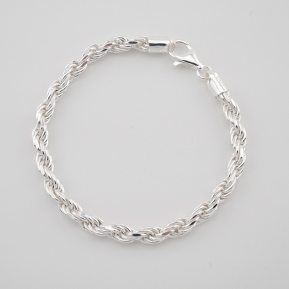 Silver braided bracelet on a light gray background