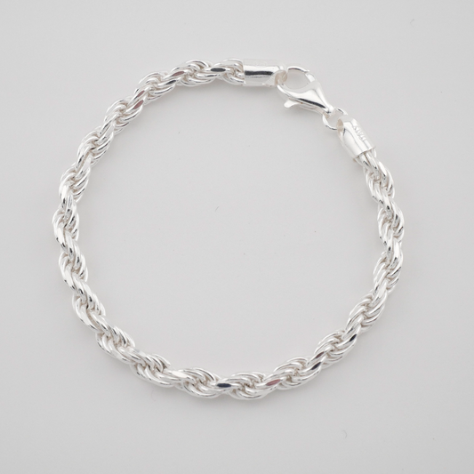 Silver braided bracelet on a light gray background