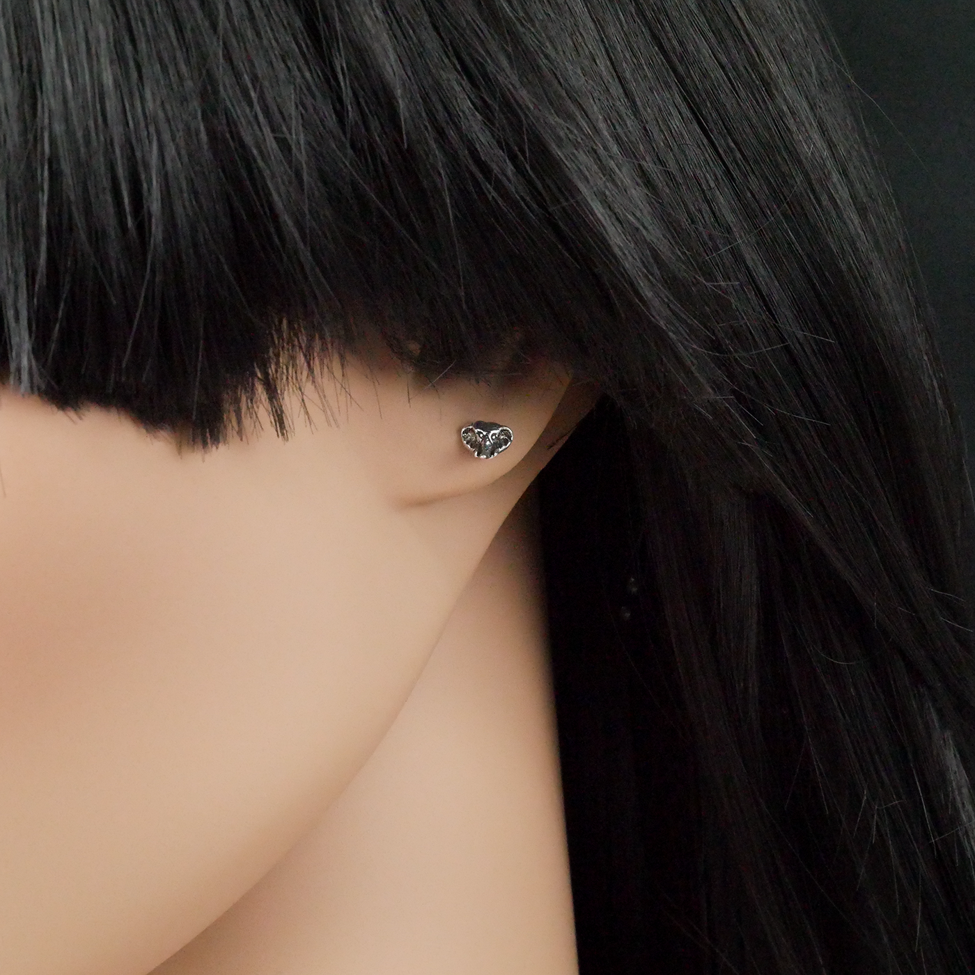 Elephant head shaped earring on a mannequin with black hair