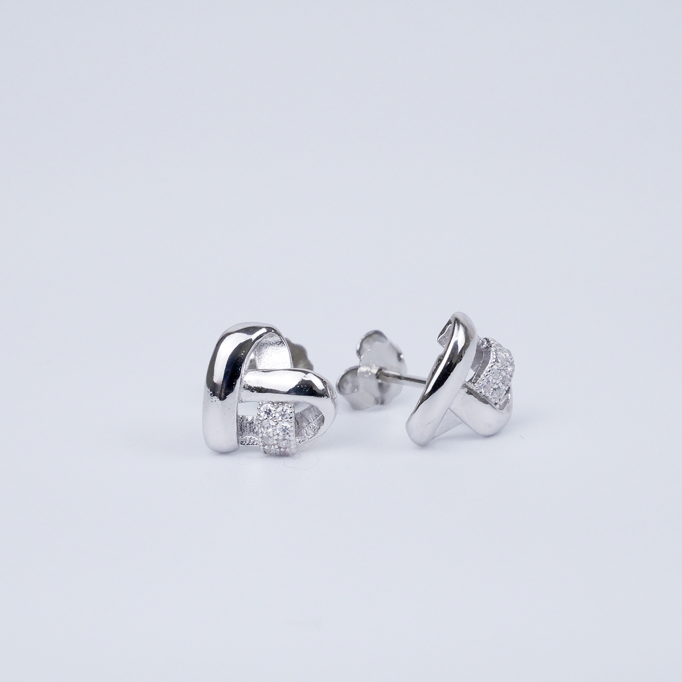 Pair of silver earrings on a light grey background