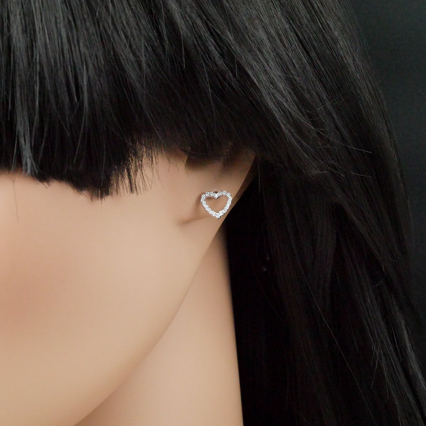 Heart-shaped earring worn by a person with black hair