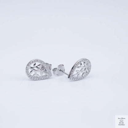 Silver earrings with intricate designs on a light gray background