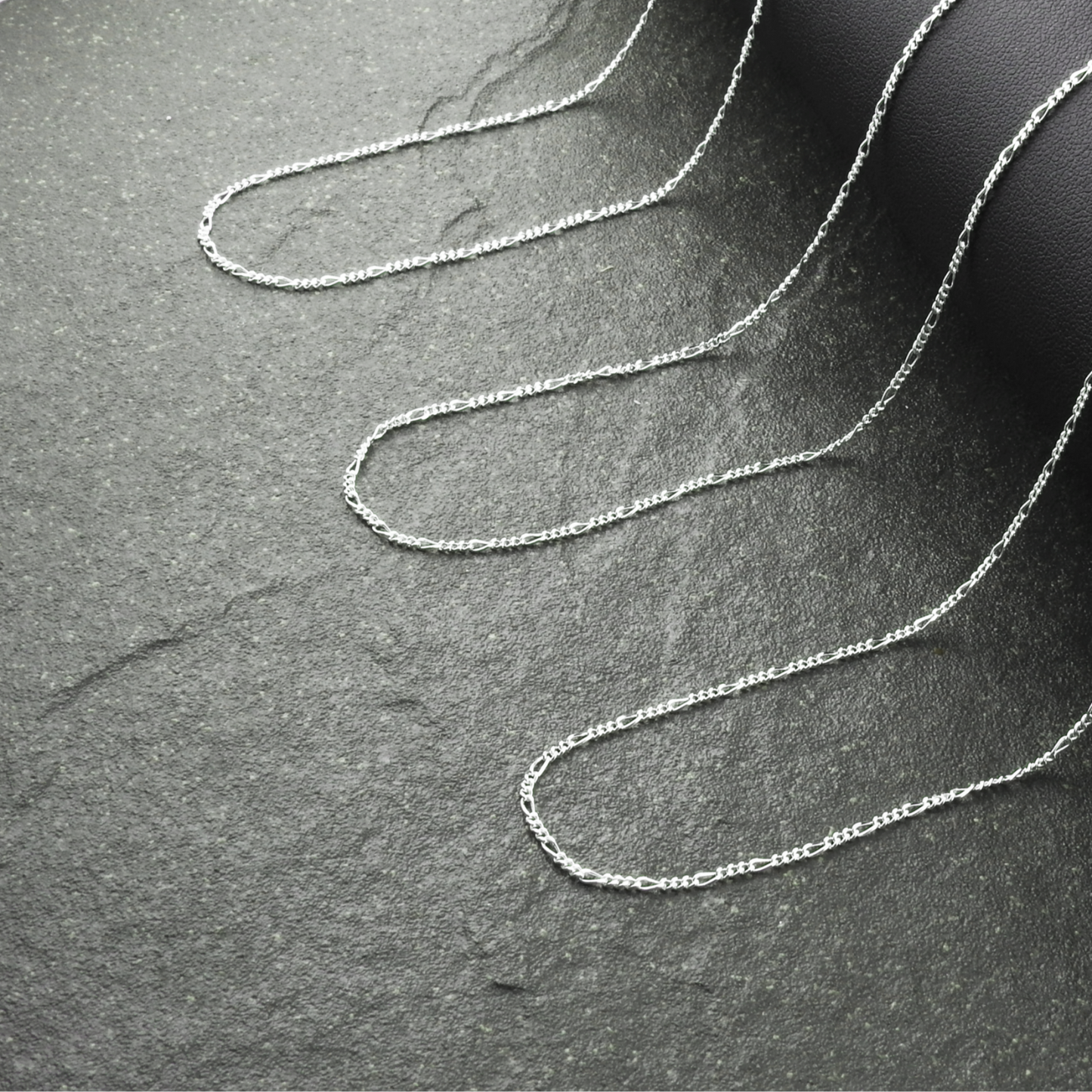 Silver chain on a dark gray surface