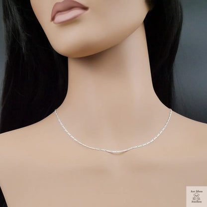 Silver necklace on a mannequin with a plain background