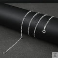 Silver fine figaro chain necklace on a dark surface