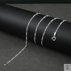 Silver fine figaro chain necklace on a dark surface