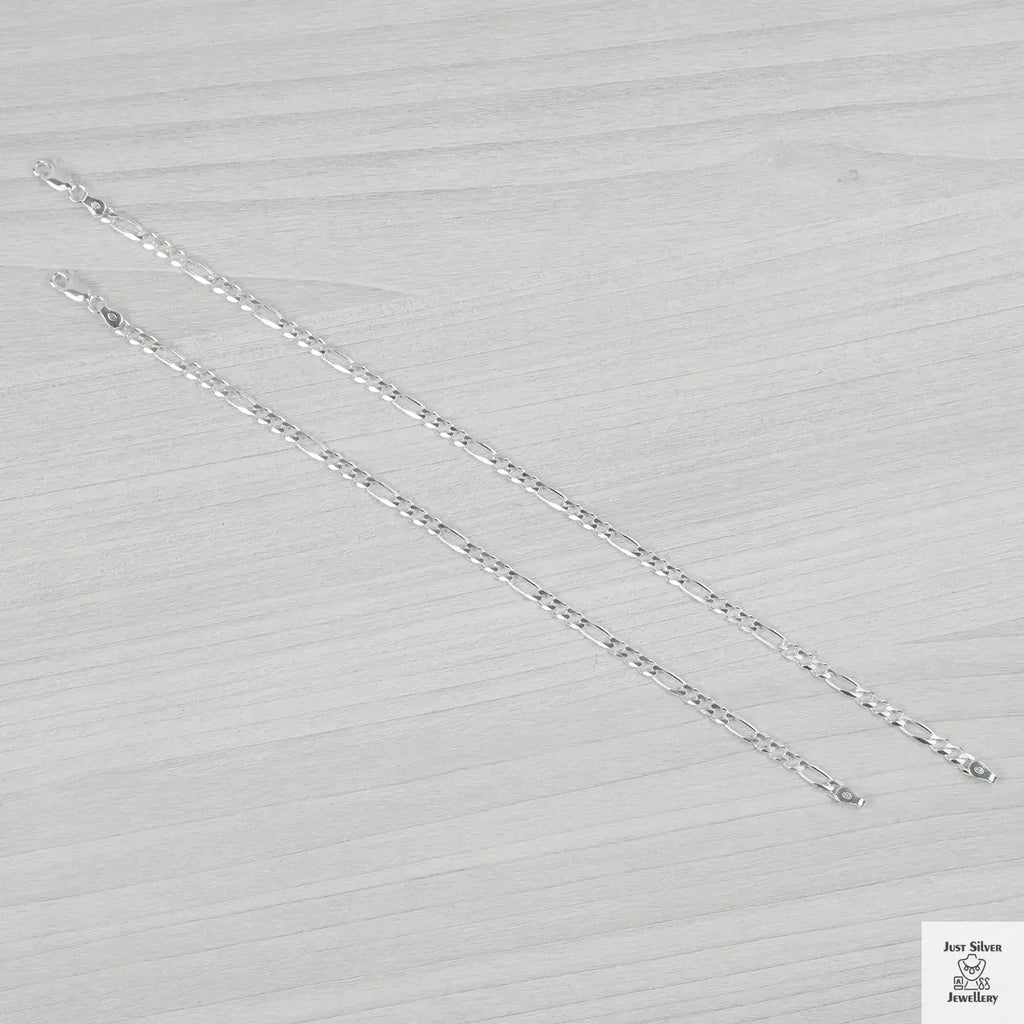 Silver bracelets on a light grey textured background