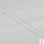 Silver bracelets on a light grey textured background