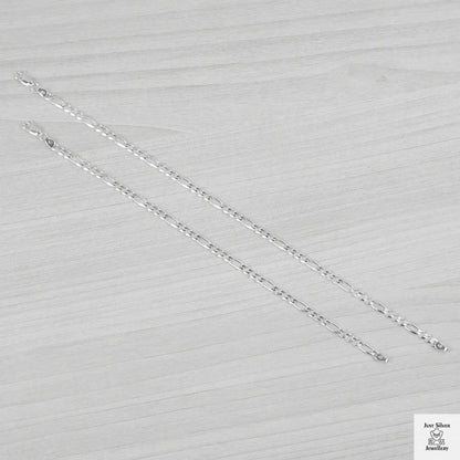 Silver bracelets on a light grey textured background