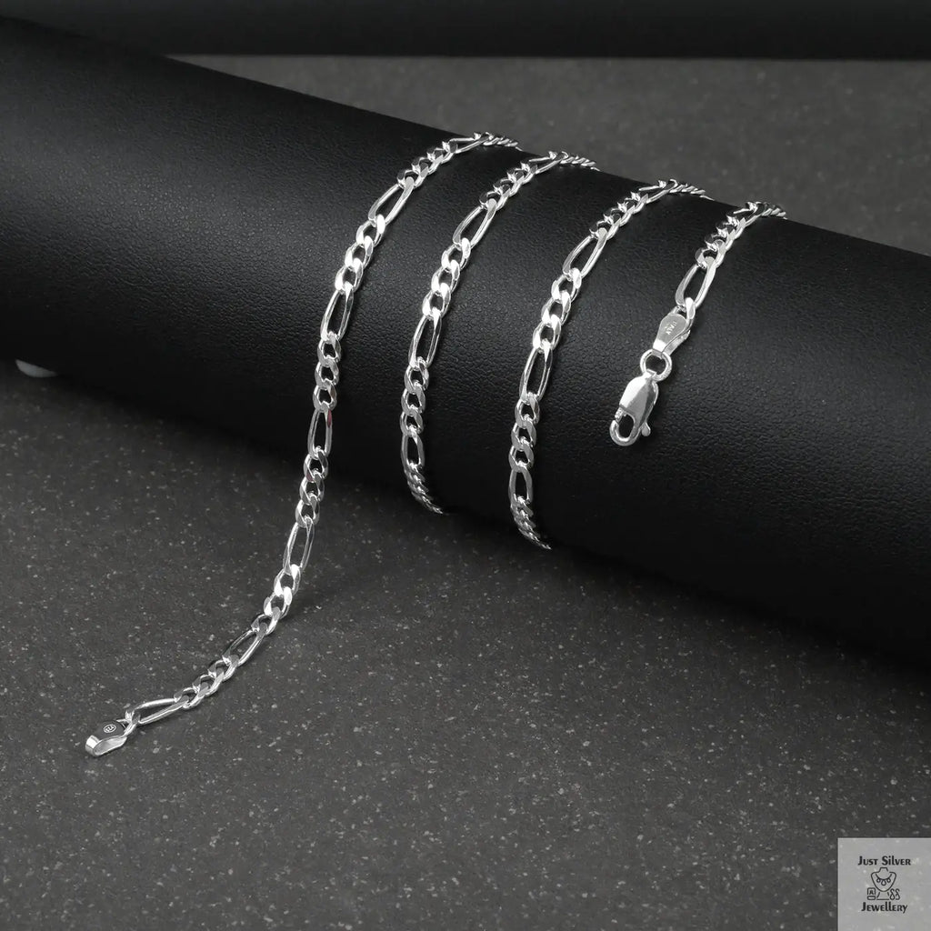 Silver figaro chain on a dark surface
