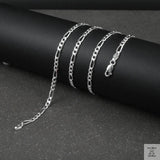 Silver figaro chain on a dark surface