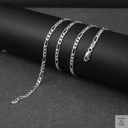 Silver figaro chain on a dark surface