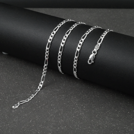 Silver figaro chain on a dark surface