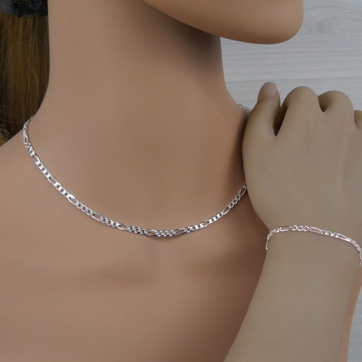 Silver figaro necklace and bracelet on a mannequin
