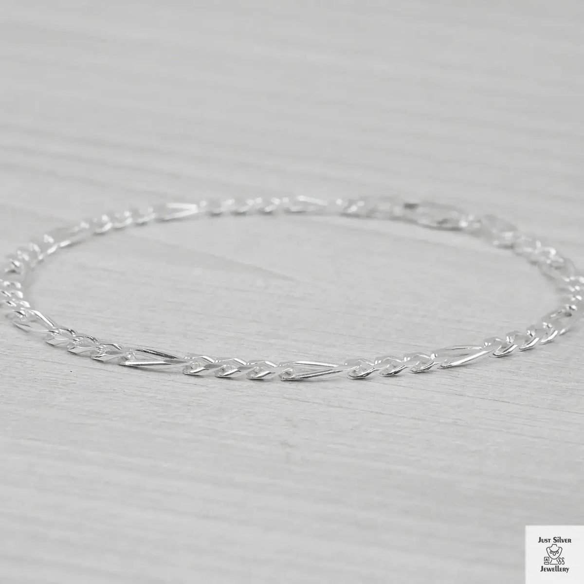 Silver bracelet on a light grey background