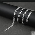 Silver figaro chain on a dark surface